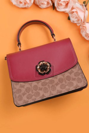 Photo for Red female handbag and a beautiful flower. - Royalty Free Image
