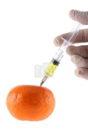 Téléchargez les photos : Orange fraîche avec une seringue. Concept pour les aliments génétiquement modifiés - en image libre de droit