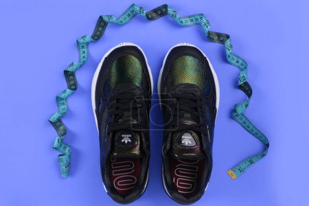 Photo for Jeddah, Saudi Arabia - 25th July, 2020: ADIDAS sport shoe, on blue background. Product shot. Adidas is a German corporation that designs and manufactures sports shoes, clothing and accessories - Royalty Free Image