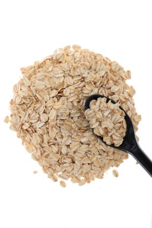 Photo for Uncooked oats in bowl with spoon - Royalty Free Image