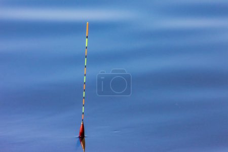 Téléchargez les photos : Beau flotteur de pêche est sur le lac et en attente de la morsure de poisson - en image libre de droit