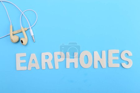 Téléchargez les photos : Écouteurs de mots et écouteurs sur bleu - en image libre de droit