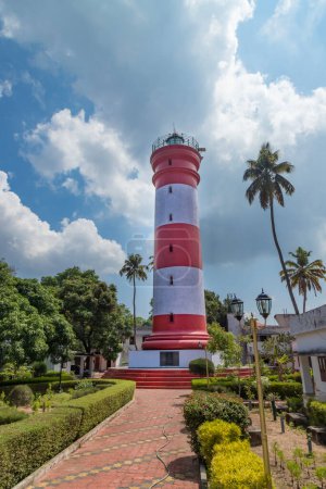 Foto de Faro de Alleppey con rayas rojas y blancas con palmeras en el cielo azul sin nubes, Aleppuzha, Kerala, India - Imagen libre de derechos