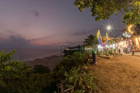 Photo for Varkala,Kerala,India 10 March 2022 Kerala, India. Varkala beach at night, various cafes and restaurants at the cliff with colorful sunset sky and motion blurred Laccadive Sea and Papanasam beach in Kerala, India - Royalty Free Image