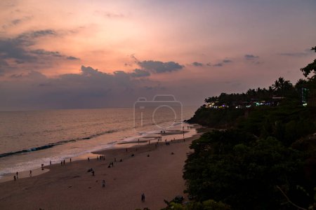 Photo for Kerala, India. Varkala beach at night, various cafes and restaurants at the cliff with colorful sunset sky . - Royalty Free Image