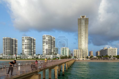 Photo for Sunny Isles Beach, USA - August 17, 2014: people catch fishes at  the pier in Sunny Isles Beach, USA. In 1936, Milwaukee malt magnate Kurtis built the Sunny Isles pier. - Royalty Free Image