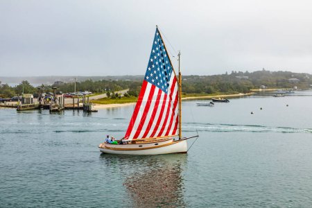 Téléchargez les photos : EDGARTOWN, États-Unis - 25 SeP 2017 : un vieux voilier avec des étoiles et des rayures voiles entre dans le port d'Edgartown, sur l'île de Marthas vignoble. - en image libre de droit