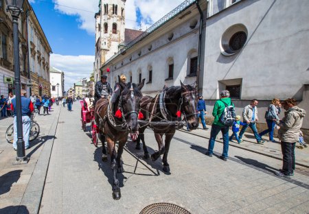 Téléchargez les photos : Cracovie, Pologne - 4 mai 2014 : Chariot tiré par des chevaux sur la place du marché, standardisé la couleur, longueur totale ne dépassant pas 7,0 m, peut être attelé à un maximum de deux chevaux à Cracovie, Pologne. - en image libre de droit