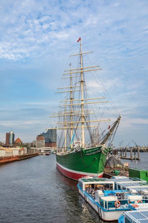 Foto de HAMBURG, ALEMANIA - 2 AGO 2017: vista al puerto de Hamburgo con el histórico Rickmer Rickmers en el landungsbruecken. El barco histórico sirve como museo hoy en día. - Imagen libre de derechos
