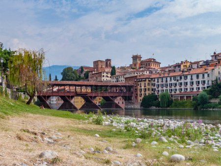 Téléchargez les photos : Le vieux pont en bois enjambe la rivière Brenta au village romantique Basano del Grappa - en image libre de droit
