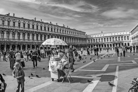 Téléchargez les photos : Venise, Italie - 9 avril 2007 : les gens visitent la place Piazza San Marco à Venise, Italie avec des colombes qui volent autour. - en image libre de droit