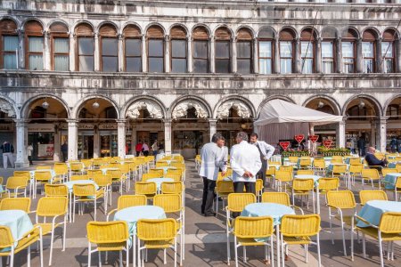 Photo for Venice, Italy - April 9, 2007: waiters of a cafe in white dresses waiting for tourists at St. Mark's square in Venice. - Royalty Free Image
