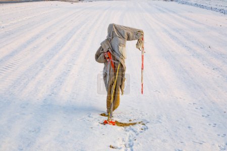 Foto de Espantapájaros tristes, andrajosos y helados en invierno en el campo de nieve - Imagen libre de derechos