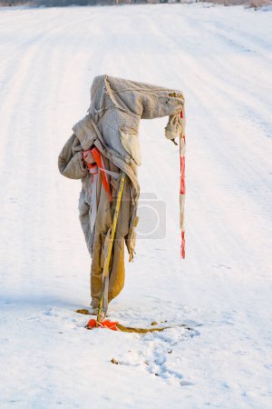 Téléchargez les photos : Épouvantail triste, déchiqueté et gelé en hiver sur le champ de neige - en image libre de droit