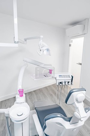 Foto de Gabinete dental moderno con lámpara, silla y equipo completo - Imagen libre de derechos