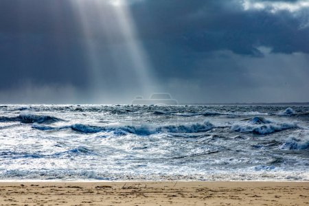 Photo for Sea landscape with huge waves and a lightbeam in Sylt, Germany - Royalty Free Image