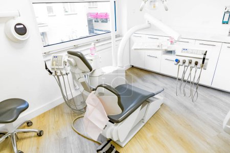 Téléchargez les photos : Armoire dentaire moderne avec lampe, chaise et équipement complet - en image libre de droit