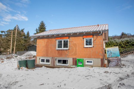Foto de Fischbach, Alemania- 11 de febrero de 2021: construcción de una casa nueva en el paisaje invernal. - Imagen libre de derechos