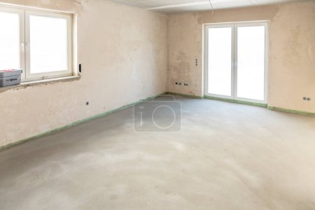 Téléchargez les photos : Maison neuve avec mur en plâtre et estrich au sol en raW CONDITION - en image libre de droit