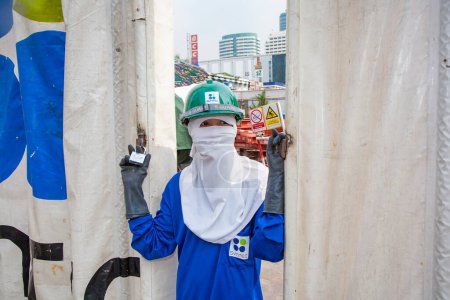 Photo for Bangkok, Thailand - May 11, 2009: female worker in working dress poses for a portrait in safety clothes at the construction site in Bangkok. - Royalty Free Image