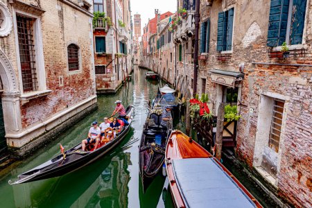 Foto de Venecia, Italia - 4 de julio de 2021: canal estrecho en Venecia con casas históricas y una góndola en Venecia, Italia - Imagen libre de derechos