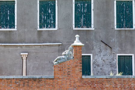 Téléchargez les photos : Historic marble figure of a beautiful woman at a fence with closed shutter in background at island of Burano, Venice, Italy - en image libre de droit