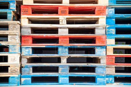 Foto de Frankfurt, Germany - January 29, 2022: pallets of european standard configuration stapled and partly marked with blue or red paint. - Imagen libre de derechos