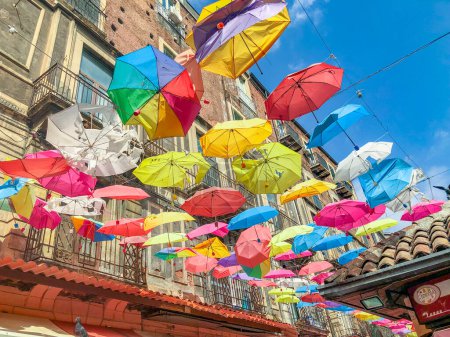 Foto de Palermo, Italia - 1 de octubre de 2022: coloridos paraguas en el casco antiguo de Palermo como decoración en la zona peatonal con fachada de antiguas casas históricas bajo el cielo azul - Imagen libre de derechos