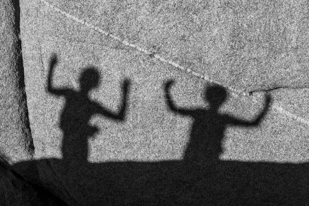 Téléchargez les photos : Enfants jouant avec les ombres sur un rocher dans le parc national de Jushua Tree - en image libre de droit