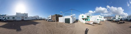 Téléchargez les photos : Famara, Espagne - 31 janvier 2023 : maisons blanches sur le terrain sablonneux de Famara, Lanzarote, le village pour les surfeurs et les personnes appréciant le calme et le calme environnant, Espagne - en image libre de droit