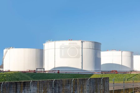 Téléchargez les photos : Tank farm in Germany with white oil and petrol silos under blue sky - en image libre de droit