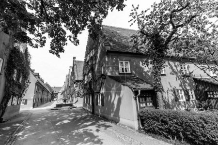 Photo for AUGSBURG, GERMANY - APRIL 29, 2015: The Fuggerei is the worlds oldest social housing complex still in use in Augsburg, Germany. - Royalty Free Image