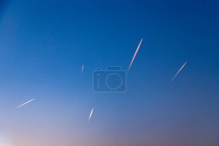 Foto de Muchos senderos de aviones en el sol de la mañana temprano en el cielo - Imagen libre de derechos