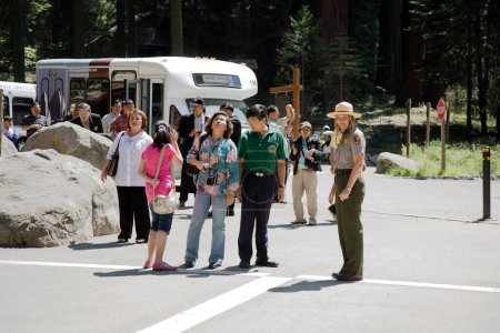 Téléchargez les photos : Giant Village, États-Unis - 21 juillet 2008 : Ranger guide un groupe de touristes à l'intérieur du parc national du séquoia et donne des explications. - en image libre de droit