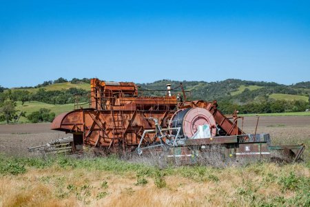 Téléchargez les photos : Solvang, États-Unis - 21 avril 2019 : vieille machine de récolte dans un champ hors service. - en image libre de droit