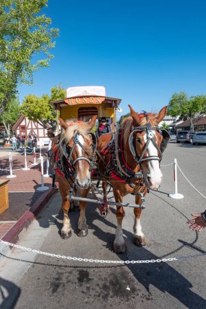 Photo for Solvang, USA - April 22, 2019:guide explains tourists the history of Solvang in a horse drawn cart and covers all important landmarks of the danish village. - Royalty Free Image