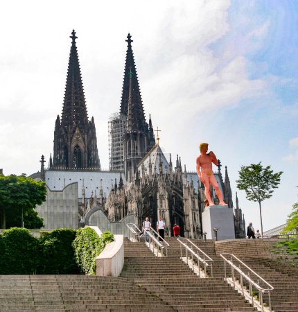 Foto de Colonia, Alemania 23 de marzo de 2007: Adam de Michelangelo in Pink está de pie frente a la cúpula de colonia en Colonia, Alemania. Colonia es la capital alemana para gays. - Imagen libre de derechos