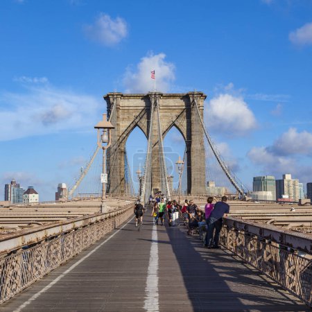 Foto de Nueva York, Estados Unidos - 9 de julio de 2010: Turistas y residentes cruzan el Puente de Brooklyn en Nueva York, Nueva York. El puente de Brooklyn es uno de los puentes colgantes más antiguos y fue terminado en 1883.. - Imagen libre de derechos