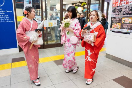 Foto de Tokio, Japón - 16 de marzo de 2023: mujeres vestidas con ropa tradicional vestidas como geishas usando el metro en Tokio. - Imagen libre de derechos