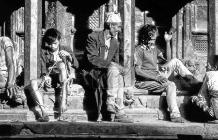 Téléchargez les photos : Bakhtapur, Népal - 1er juillet 1974 : les népalais non identifiés aiment s'asseoir au temple principal de Bakthapur, au Népal. - en image libre de droit