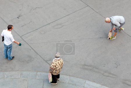 Foto de Viena, Austria - 22 de abril de 2009: pareja masculina va a dar un paseo con su perro pequeño. Enseñan hin cruzar la calle y una anciana observa la escena. - Imagen libre de derechos
