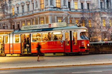 Photo for Vienna, Austria - March 23, 2009: streetcar in the first district with blurred motion of a female leg waiting for the streetcar in dawn. - Royalty Free Image