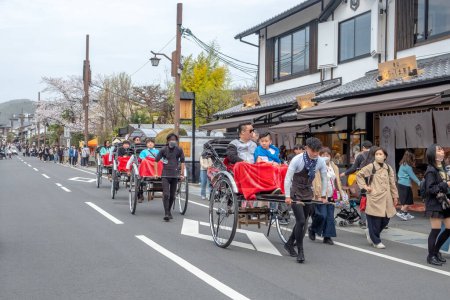 Foto de Kyoto, Japón - 25 de marzo de 2023: a los turistas japoneses les gusta ir en un viaje turístico en rickshaw en Kyoto. - Imagen libre de derechos