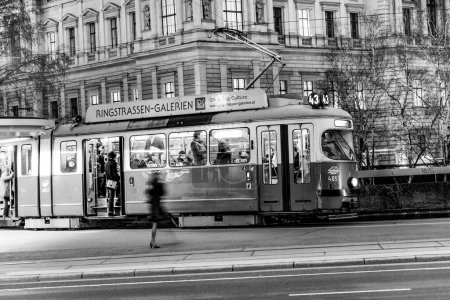 Téléchargez les photos : Vienne, Autriche - 23 mars 2009 : tramway dans le premier quartier avec le mouvement flou d'une jambe féminine attendant le tramway à l'aube. - en image libre de droit