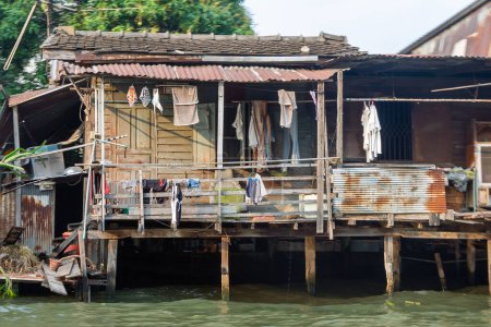 Photo for Houses at a klong in downtown Bangkok. Klongs are the canals, that branch off from Chao Phraya river, the big river of Bangkok in Thailand - Royalty Free Image