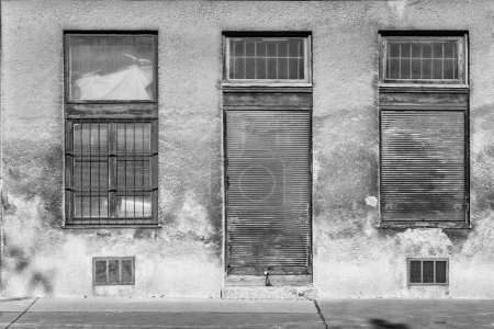 Téléchargez les photos : Porte fermée avec fenêtres fermées dans une façade de maison sale à Vienne - en image libre de droit