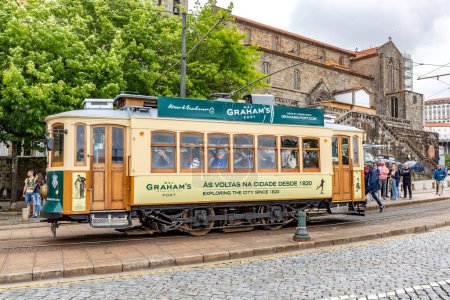 Photo for Porto, Portugal - May 4, 2023: Porto, vintage Portuguese traditional city tram Infante 1 designed with advertisements with the view on the river - Royalty Free Image