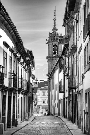 Foto de Braga, Portugal - 1 de mayo de 2023: escena callejera en el casco antiguo de Braga con fachadas históricas y personas en la madrugada. - Imagen libre de derechos