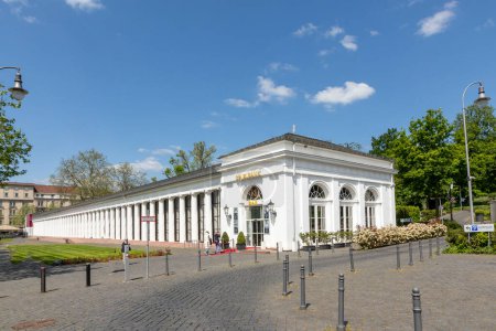 Foto de Wiesbaden, Alemania - 18 de mayo de 2023: vista al casino de Wiesbaden, la columnata blanca al lado del edificio principal del casino. La colonia alberga máquinas de juego para todos. - Imagen libre de derechos