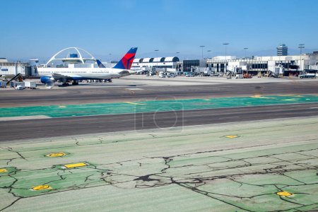 Photo for Los Angeles, USA - June 29, 2012:   cars and loaders ready to unload next aircraft, Aircrafts standing at the terminal gates ready for boarding. - Royalty Free Image